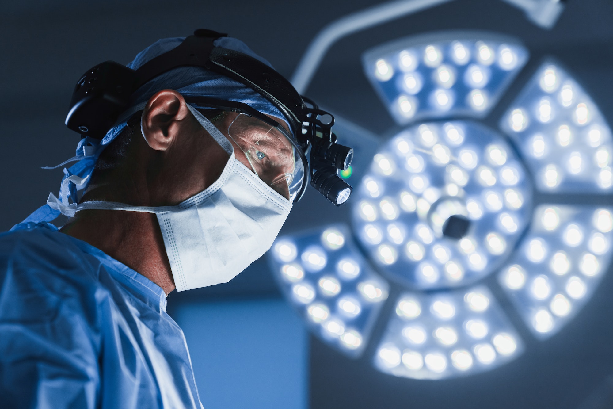 Surgery operation. Senior male surgeon in operating room with surgery equipment